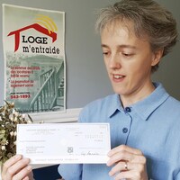 Sonia Côté tient un chèque envoyé par le pape François.