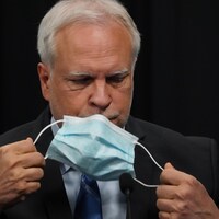 Le Dr Luc Boileau enlève son masque avant une conférence de presse.