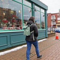 Une personne marche devant des commerces de la rue Saint-Germain, à Rimouski.