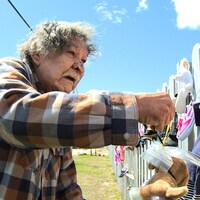 Tabi McKenzie devant la clôture du site Innu Nikamu à Mani-utenam.