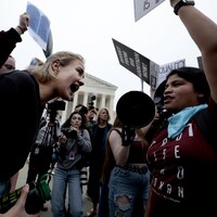 Une manifestante anti-avortement et une militante pro-choix s'affrontent devant la Cour suprême. 