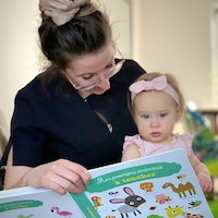Marie-Pier Bellemare et sa fille lisent un livre avec de grandes images.