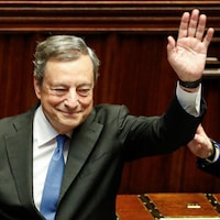Le premier ministre italien Mario Draghi salue des gens dans une salle du parlement italien.
