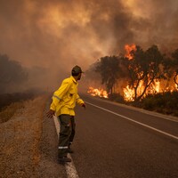 Un pompier marocain s'éloigne des flammes d'un incendie de forêt.