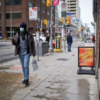 Un homme marche en portant un masque au centre-ville d'Ottawa.