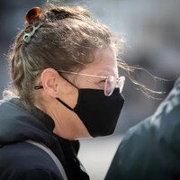 Une femme porte un masque.