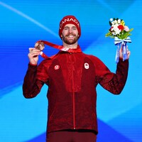Maxence Parrot, souriant, soulève la médaille à son cou.