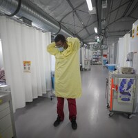 Un employé de l'hôpital met son masque.