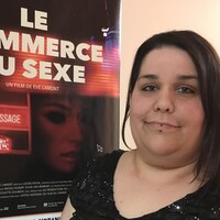 Une femme pose devant une affiche du film «Le commerce du sexe».