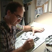 Michel Rabagliati, de profil, travaille sur une planche de Paul dans son bureau.