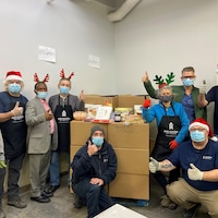 Des bénévoles de Moisson Outaouais posent devant les paniers de Noël.