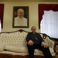 Monseigeur Albert LeGatt pose devant un portrait du pape François à Winnipeg, le 5 avril 2022.