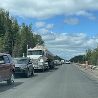 Des dizaines de véhicules sont arrêtés sur la route d'un côté. De l'autre, quelques voitures peuvent circuler dans la zone de travaux.