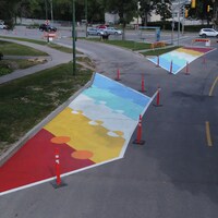 Un graffiti peint à l'été 2022 par le collectif Cool Streets Winnipeg dans le but de ralentir la circulation et assurer la sécurité des cyclistes à Winnipeg.