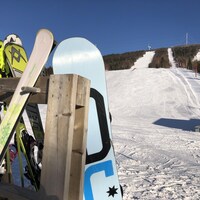 Des skis et des planches à neige devant la station de ski.