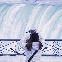 Une femme prend une photo des chutes Niagara.