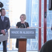 La première ministre Rachel Notley aux côtés du ministre du Développement économique et du Commerce de l'Alberta, Deron Bilous, devant des caméras au dernier étage de la Tour Calgary.