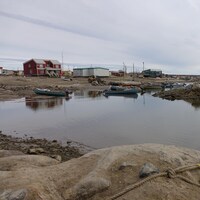 Un bâteau flotte sur l'eau, près de la communauté de Clyde River, au Nunavut.