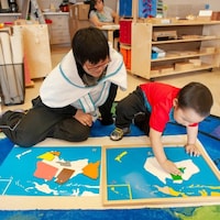 Une femme supervise un jeune enfant dans une garderie.