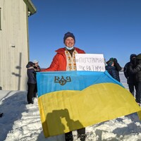 Oleksii Pivtorak, tout sourire, brandit un drapeau de son pays.