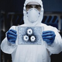 Un homme en tenue de laboratoire présente une image d'un virus.