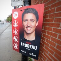 Une pancarte électorale montrant le chef libéral Justin Trudeau est accrochée sur un poteau dans la circonscription de Papineau à Montréal. On y voit Justin Trudeau souriant.