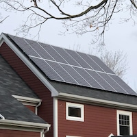 Des panneaux solaires recouvrent le toit d'une maison.