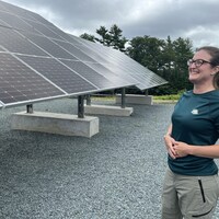 Jennifer Eaton devant des panneaux solaires.