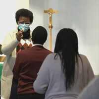 Des fidèles font la queue pendant que l'hostie est donnée à la paroisse Saint-Thomas d'Aquin à Edmonton.
