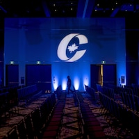 La silhouette d'un homme dans une pièce vide avec le logo du Parti conservateur du Canada. 