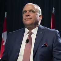 Le ministre québécois de l'Économie et de l'Innovation, Pierre Fitzgibbon, assis durant une conférence de presse.
