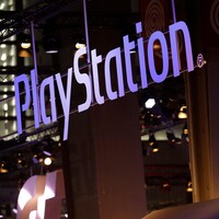 Le logo de la compagnie PlayStation est affiché et illuminé 
a l'extérieur d'un édifice.