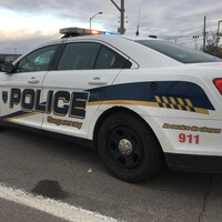 Un véhicule du Service de police de Saguenay est à l'arrêt. Ses gyrophares sont allumés.