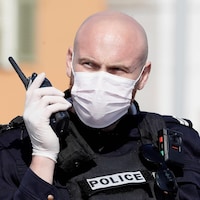 Un policier portant un masque et des gants.