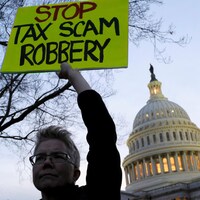 Une manifestante brandit une pancarte contre la réforme fiscale devant le Capitole, à Washington.