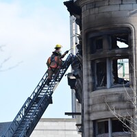 Des pompiers grimpent dans une échelle.