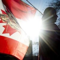 Photo d'un membre d'une Première Nation avec un drapeau canadien.