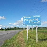 Une affiche le long d'une route devant une ferme
