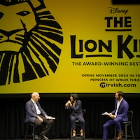 David Mirvish, la mairesse de Toronto Olivia Chow et Sébastien Heins sur une scène devant une affiche du Roi lion. 