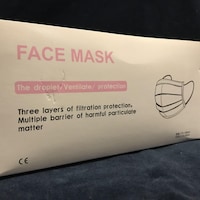 Une boite contenant des masques avec un étiquetage unilingue anglophone.