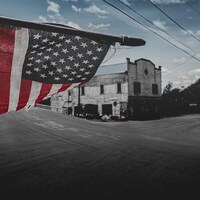 Le drapeau américain flotte devant une vieille bâtisse.
