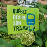 Une affiche du groupe Québec désire son tramway plantée sur le terrain d'une maison.