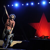 Le chanteur Zach de la Rocha lève le bras pendant un concert de Rage Against the Machine.