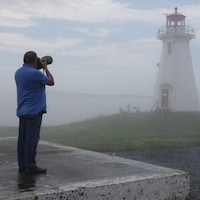 Ralph Eldridge photographie un phare plus loin dans la brume.