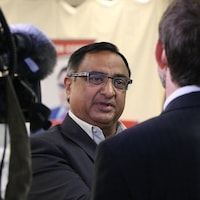 Le portrait d'un homme qui discute avec un journaliste.