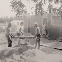 Des jeunes construisent une maison, photo en noir et blanc. 