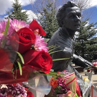 Une statue de Guy Lafleur recouverte de fleurs.