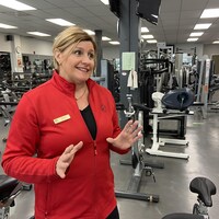 Une femme parle dans une salle de gym.