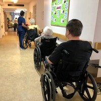 Des résidents d'un centre de soins de longue durée attendent dans leur fauteuil roulant.