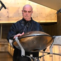 Un homme joue le handpan, un instrument à percussion en métal, qui ressemble à une soucoupe volante
